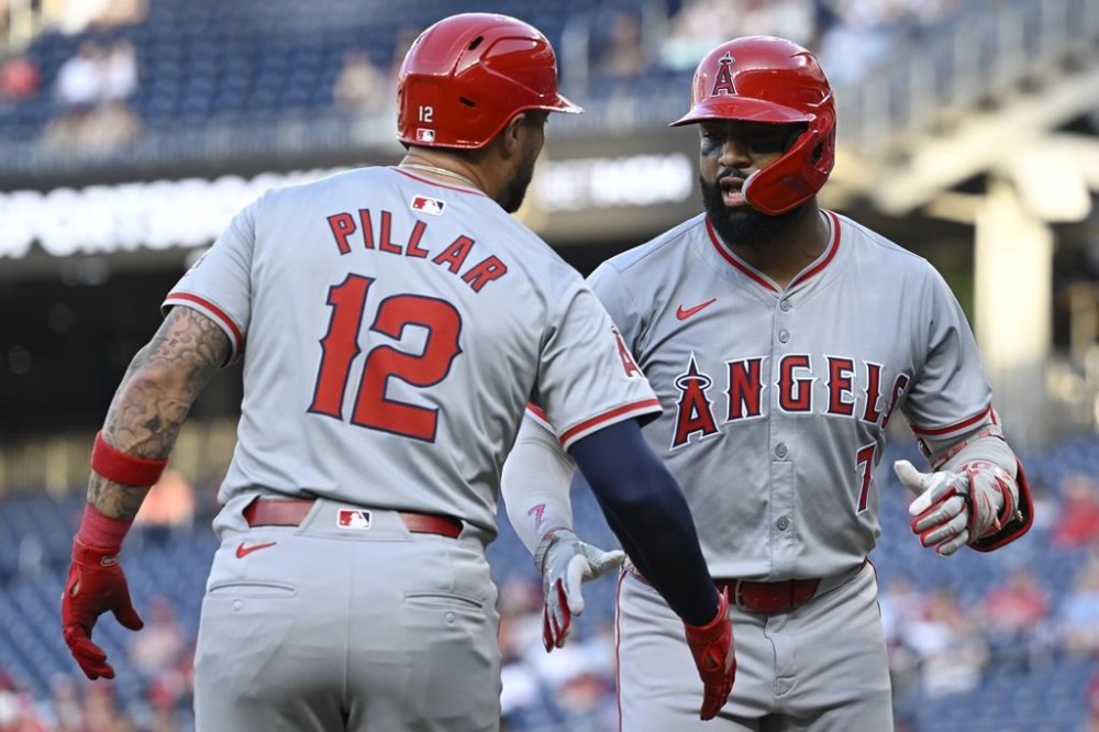Los Angeles Angels' Jo Adell, right, is greeted by teammate Kevin Pillar at home plate on a two-run home run in which he also drove in Pillar during the second inning of a baseball game against the Washington Nationals, Friday, Aug. 9, 2024, in Washington. (AP Photo/John McDonnell)