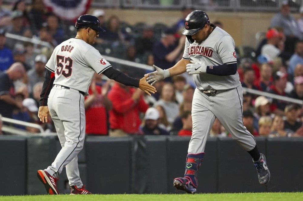 Cleveland Guardians' Josh Naylor celebrates after his three-run home run with third base coach Rouglas Odor as he runs the bases during the fifth inning of the second game of a baseball doubleheader against the Minnesota Twins, Friday, Aug. 9, 2024, in Minneapolis. (AP Photo/Matt Krohn)