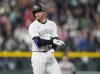 Colorado Rockies' Ryan McMahon gestures to the dugout after hitting an RBI double off Atlanta Braves relief pitcher A.J. Minter in the seventh inning of a baseball game Friday, Aug. 9, 2024, in Denver. (AP Photo/David Zalubowski)