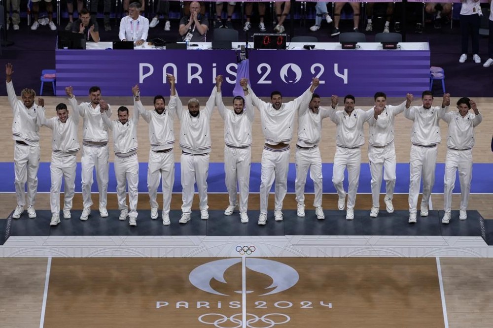 The French volleyball team step onto the podium to receive their gold medals after defeating Poland in the final men's volleyball match at the 2024 Summer Olympics, Saturday, Aug. 10, 2024, in Paris, France. (AP Photo/Charlie Riedel)