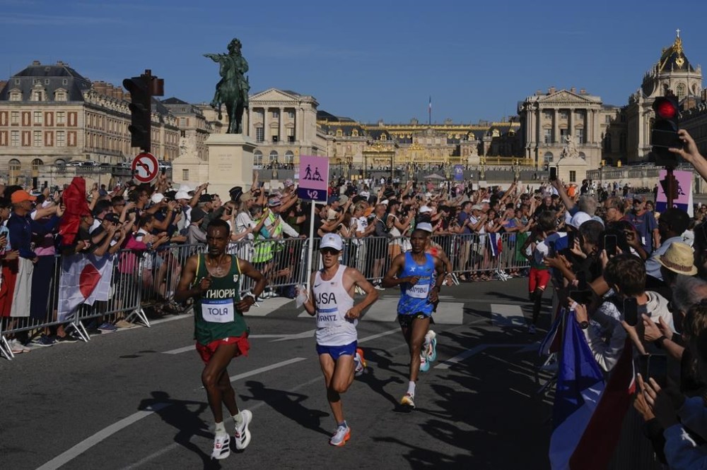 Competitors run past spectators near the Palace of Versailles during the men's marathon at the 2024 Summer Olympics, Saturday, Aug. 10, 2024, in Versailles, France. THE CANADIAN PRESS/AP-POOL, Rebecca Blackwell