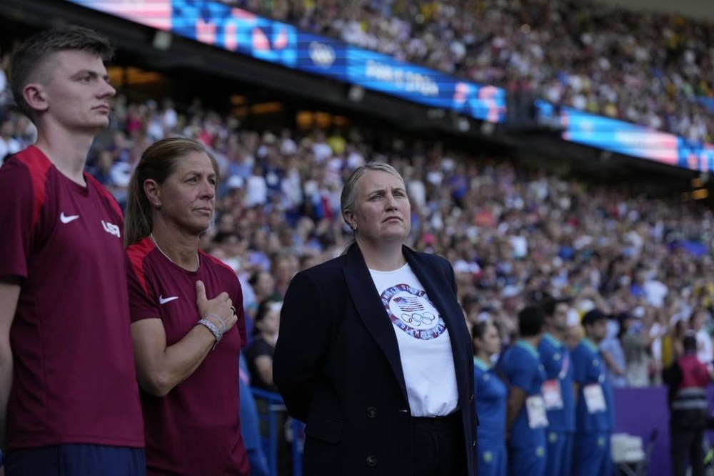 Head coach Emma Hayes of the United States, right, stands during the national anthems before the women's soccer gold medal match between Brazil and the United States at the Parc des Princes during the 2024 Summer Olympics, Saturday, Aug. 10, 2024, in Paris, France. (AP Photo/Francisco Seco)