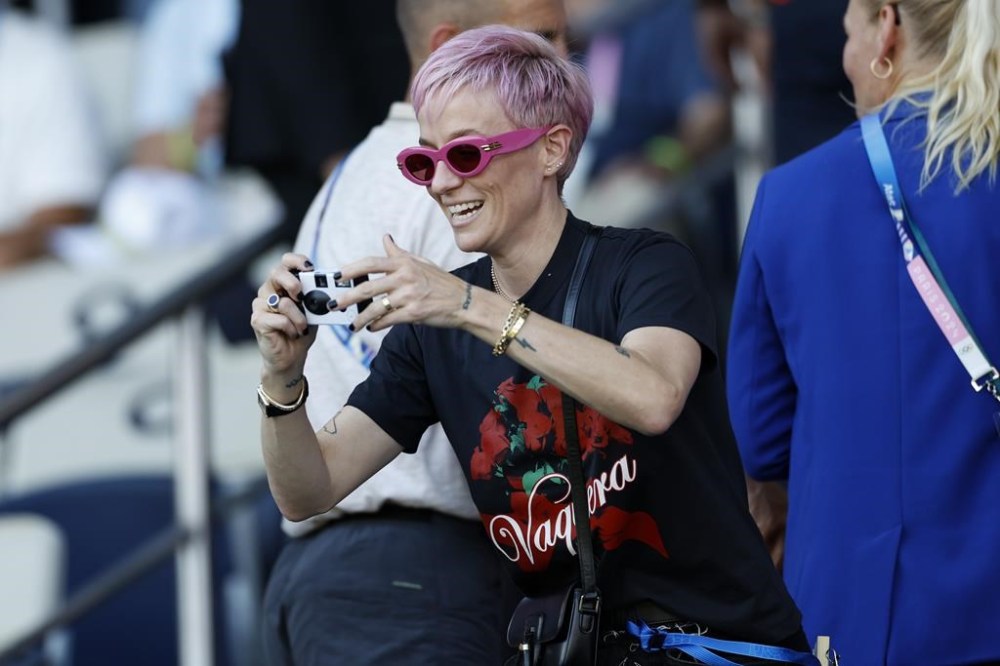 Former US soccer player Megan Rapinoe takes photos before the women's soccer gold medal match between Brazil and the United States at the Parc des Princes during the 2024 Summer Olympics, Saturday, Aug. 10, 2024, in Paris, France. (AP Photo/Aurelien Morissard)
