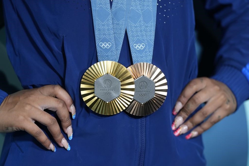 Jordan Chiles, of the United States, holds up her medals after the women's artistic gymnastics individual apparatus finals Bercy Arena at the 2024 Summer Olympics, Monday, Aug. 5, 2024, in Paris, France. (AP Photo/Charlie Riedel)
