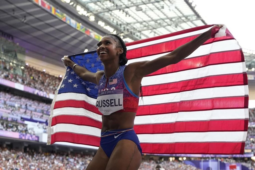 Masai Russell, of the United States, celebrates after winning the gold medal in the women's 100 meters hurdles final at the 2024 Summer Olympics, Saturday, Aug. 10, 2024, in Saint-Denis, France. (AP Photo/Ashley Landis)