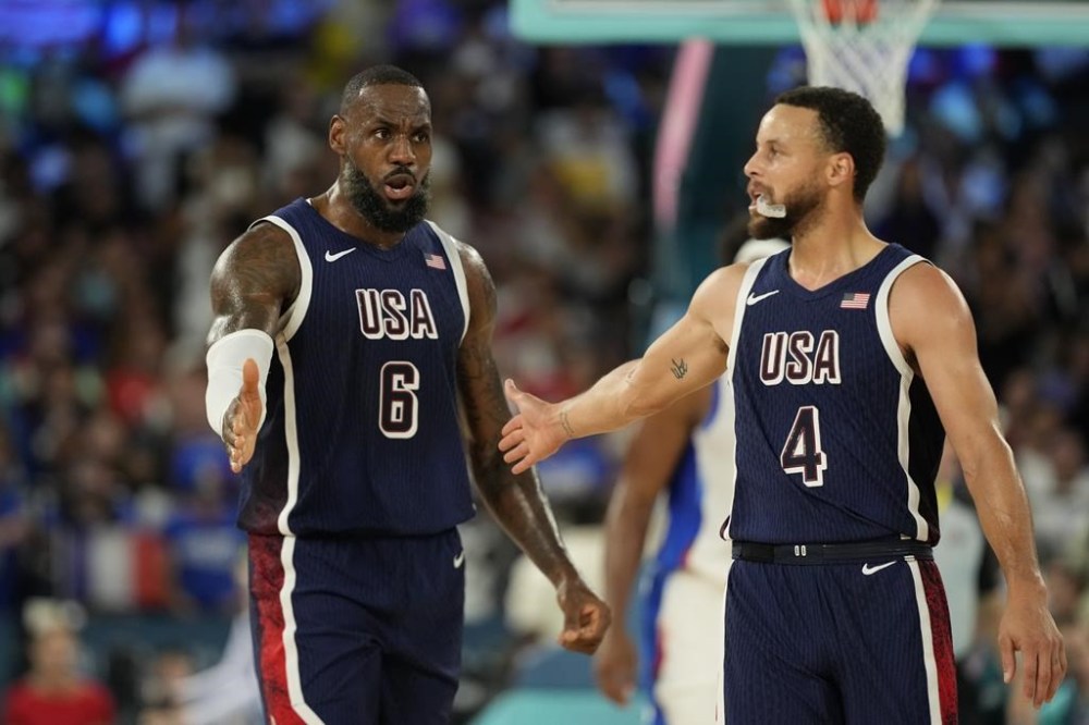 United States' LeBron James (6) and United States' Stephen Curry (4) celebrates after scoring a basket against France during a men's gold medal basketball game at Bercy Arena at the 2024 Summer Olympics, Saturday, Aug. 10, 2024, in Paris, France. (AP Photo/Mark J. Terrill)