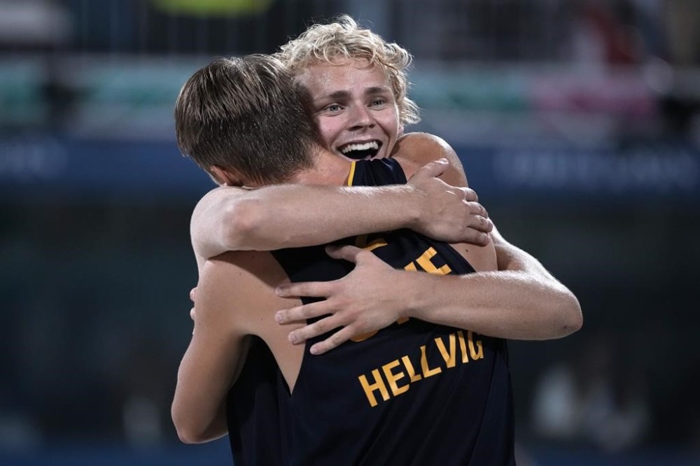 Sweden's David Ahman, facing, embraces Sweden's Jonatan Hellvig after winning the beach volleyball men's gold medal match between Sweden and Germany at the 2024 Summer Olympics, Saturday, Aug. 10, 2024, in Paris, France. (AP Photo/Louise Delmotte)