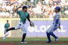 Seattle Mariners shortstop Leo Rivas, left, puts out New York Mets' Francisco Lindor (12) at second base and throws to first for a double play during the first inning of a baseball game, Saturday, Aug. 10, 2024, in Seattle. (AP Photo/Jason Redmond)