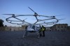 People gather at a Volocopter aircraft before a test flight on the last day of the 2024 Olympics at the 2024 Summer Olympics, Sunday, Aug. 11, 2024, in Versailles, France. (AP Photo/Mosa'ab Elshamy)