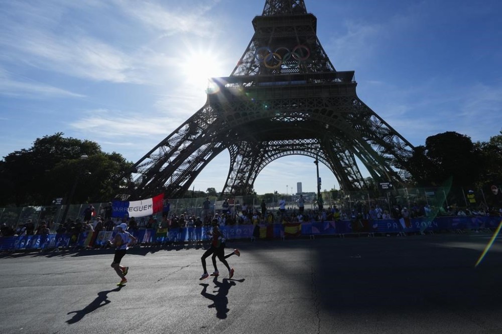 Competitors run past the Eiffel Tower during the men's marathon at the 2024 Summer Olympics, Saturday, Aug. 10, 2024, in Paris, France. (AP Photo/Rebecca Blackwell, Pool)