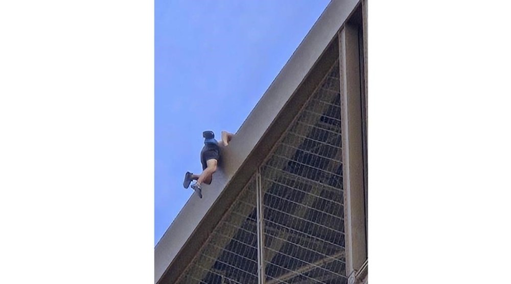 In this photo provided by Nickey Worlock, a man climbs the Eiffel Tower, during the 2024 Summer Olympics, Sunday, Aug. 11, 2024, in Paris France. (Nickey Worlock via AP)
