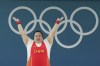 Li Wenwen of China celebrates after finishing in the first place to win the gold medal during the women's +81kg weightlifting event at the 2024 Summer Olympics, Sunday, Aug. 11, 2024, in Paris, France. (AP Photo/Kin Cheung)