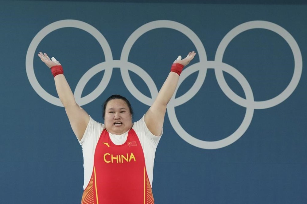 Li Wenwen of China celebrates after finishing in the first place to win the gold medal during the women's +81kg weightlifting event at the 2024 Summer Olympics, Sunday, Aug. 11, 2024, in Paris, France. (AP Photo/Kin Cheung)