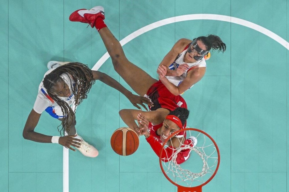 United States' A'ja Wilson (9) battles to shoot for goal as Dominique Malonga (14), of France, and Sarah Michel Boury (10), of France, attempt to block, during a women's gold medal basketball game between the United States and France at Bercy Arena at the 2024 Summer Olympics, Sunday, Aug. 11, 2024, in Paris, France. (Aris Messinis/Pool Photo via AP)