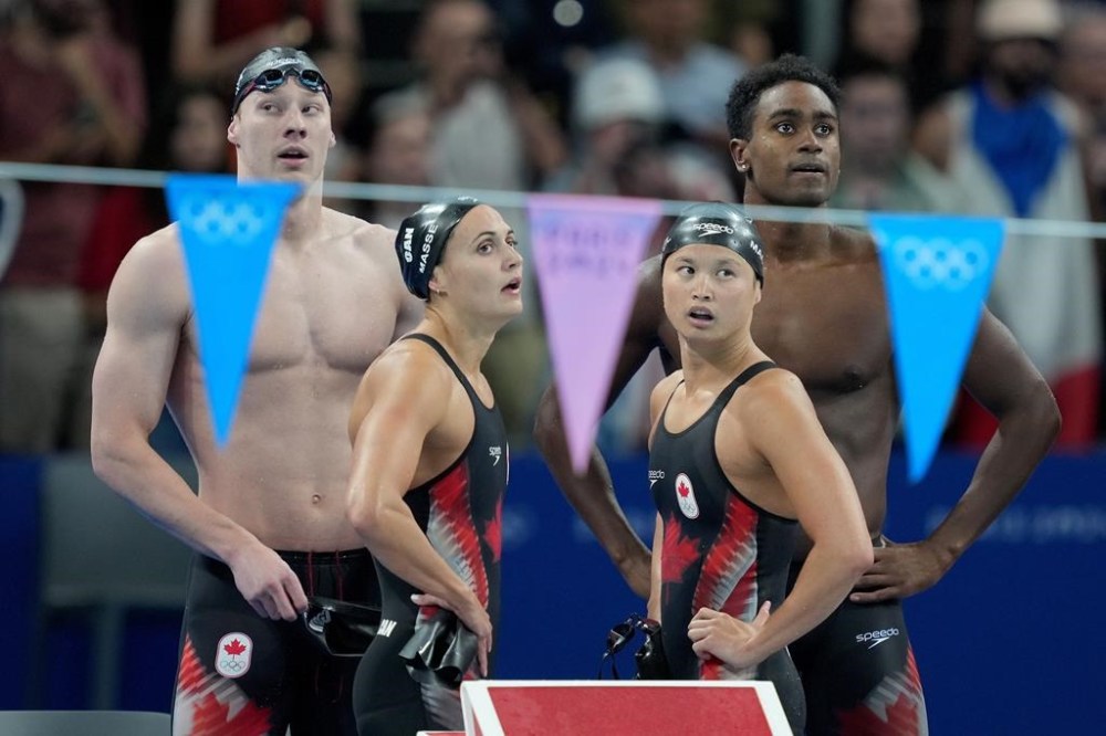 Canada's Finlay Knox, left to right, of Okotoks, Alta., Kylie Masse, of Lasalle, Ont., Maggie Mac Neil, of London, Ont., and Josh Liendo, of Toronto, look on as the scores are displayed after competing in the 4 x 100m mixed medley relay during the 2024 Summer Olympic Games, in Nanterre, France, Saturday, Aug. 3, 2024. THE CANADIAN PRESS/Christinne Muschi