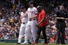 Boston Red Sox starting pitcher James Paxton limps off the field between manager Alex Cora, left, and a trainer during the first inning of a baseball game against the Houston Astros, Sunday, Aug. 11, 2024, in Boston. (AP Photo/Michael Dwyer)