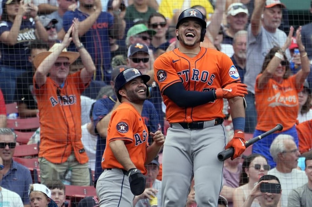Houston Astros' Yainer Diaz, right, celebrates the three-run home run by Alex Bregman that also drove in Jose Altuve, left, during the fifth inning of a baseball game against the Boston Red Sox, Sunday, Aug. 11, 2024, in Boston. (AP Photo/Michael Dwyer)