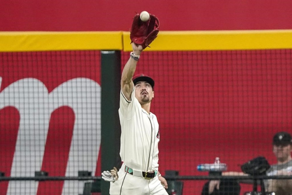 Arizona Diamondbacks outfielder Corbin Carroll (7) catches a fly ball off the bat of Philadelphia Phillies' J.T. Realmuto during the ninth inning of a baseball game Sunday, Aug 11, 2024, in Phoenix. Arizona won 12-5. (AP Photo/Darryl Webb)