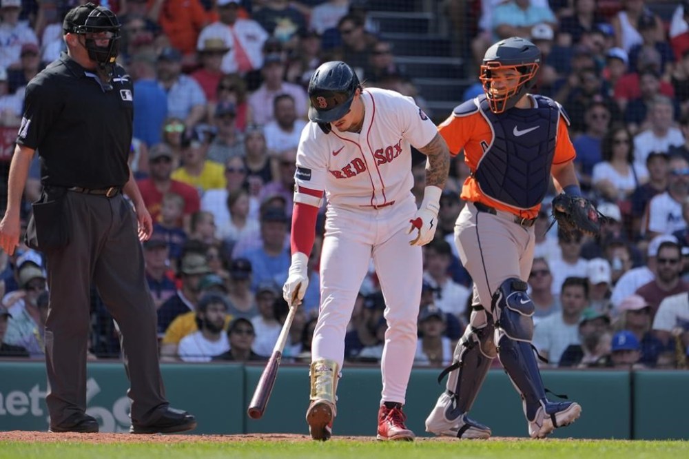 Boston Red Sox's Jarren Duran puts his bat down beside Houston Astros catcher Yainer Diaz after taking a walk during the sixth inning of a baseball game, Sunday, Aug. 11, 2024, in Boston. (AP Photo/Michael Dwyer)