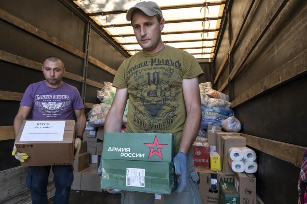 Volunteers unload humanitarian aid to people evacuated from a fighting between Russian and Ukrainian forces in Kursk region, at a temporary residence center in Kursk, Russia, Sunday, Aug. 11, 2024. (AP Photo)