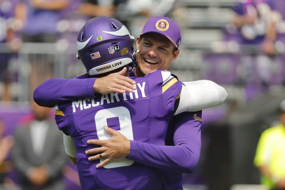 Minnesota Vikings head coach Kevin O'Connell, right, hugs quarterback J.J. McCarthy (9) before an NFL football game against the Las Vegas Raiders, Saturday, Aug. 10, 2024, in Minneapolis. (AP Photo/Bruce Kluckhohn)
