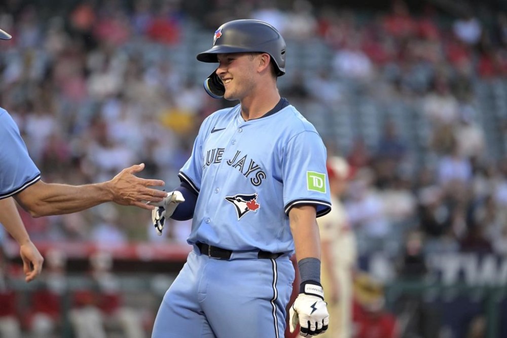 Toronto Blue Jays' Will Wagner, right reacts at first base after hitting an RBI single during the third inning of a baseball game against the Los Angeles Angels, Monday, Aug. 12, 2024, in Anaheim, Calif. (AP Photo/Jayne-Kamin-Oncea)