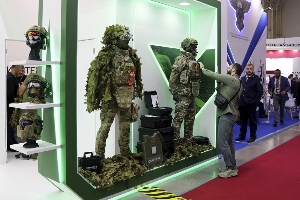 In this photo released by Russian Defense Ministry press service on Tuesday, Aug. 13, 2024, a visitor examines military equipment displayed at Army-2024 military and technical forum at Patriot Park outside of Moscow, Russia. (Russian Defense Ministry Press Service via AP)