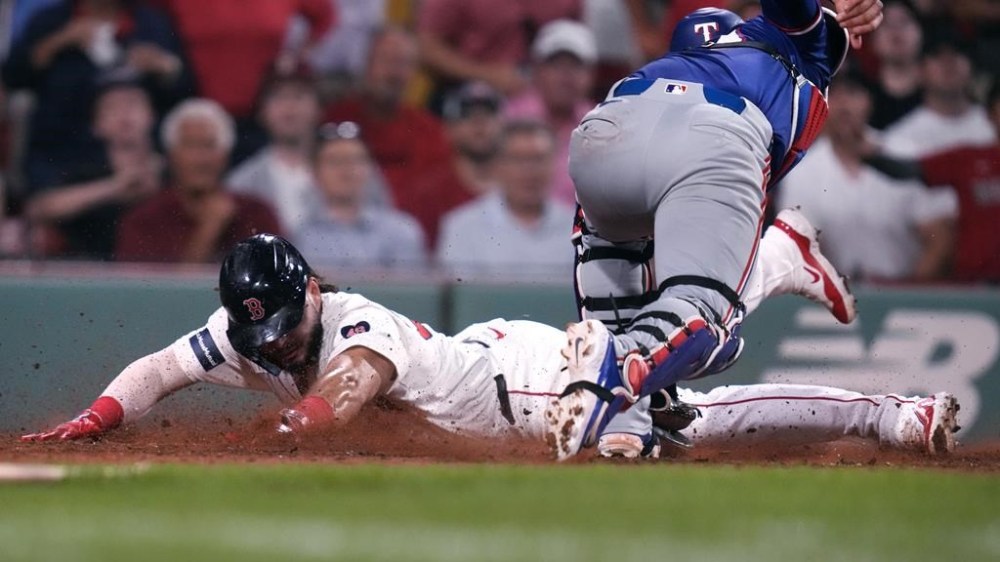 Boston Red Sox's Wilyer Abreu, left, beats the tag by Texas Rangers catcher Carson Kelly to score on a single by Dominic Smith during the eighth inning of a baseball game at Fenway Park, Tuesday, Aug. 13, 2024, in Boston. (AP Photo/Charles Krupa)