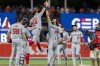 Washington Nationals third baseman Ildemaro Vargas (14) and Washington Nationals left fielder James Wood (29) celebrate their team's win over the Baltimore Orioles after a baseball game Tuesday, Aug. 13, 2024, in Baltimore. (AP Photo/Stephanie Scarbrough)