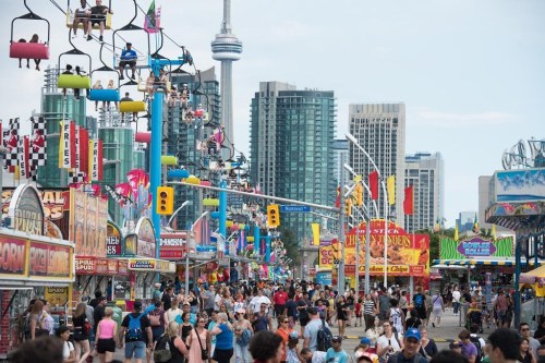 Crowds make their way through the midway during opening day of the Canadian National Exhibition in Toronto on Friday, August 19, 2022. The Canadian National Exhibition (CNE) is returning for another year this Friday and will include an eclectic mix of foods, with a focus on giant-sized portions and unusual sweet and savoury combinations. THE CANADIAN PRESS/Tijana Martin