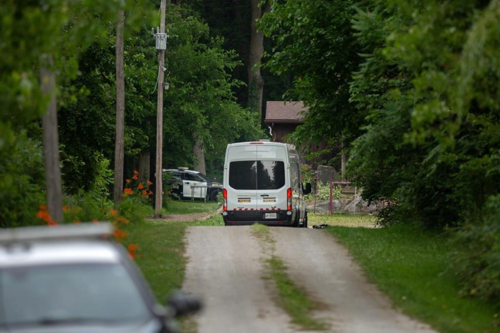 Members of the Ontario Provincial Police investigate the deaths of four people in Harrow, Ont., Friday, June 21, 2024. The council of a southwestern Ontario town where a mother and two children were found dead in their home from gunshot wounds is writing a letter to the provincial government urging it to declare intimate partner violence an epidemic. THE CANADIAN PRESS/Dax Melmer
