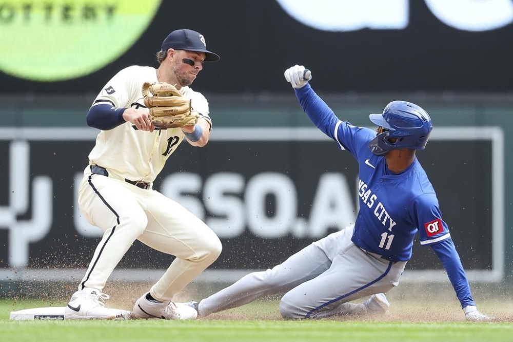 Kansas City Royals pinch runner Maikel Garcia steals second base against Minnesota Twins second baseman Kyle Farmer during the seventh inning of a baseball game, Wednesday, Aug. 14, 2024, in Minneapolis. (AP Photo/Matt Krohn)