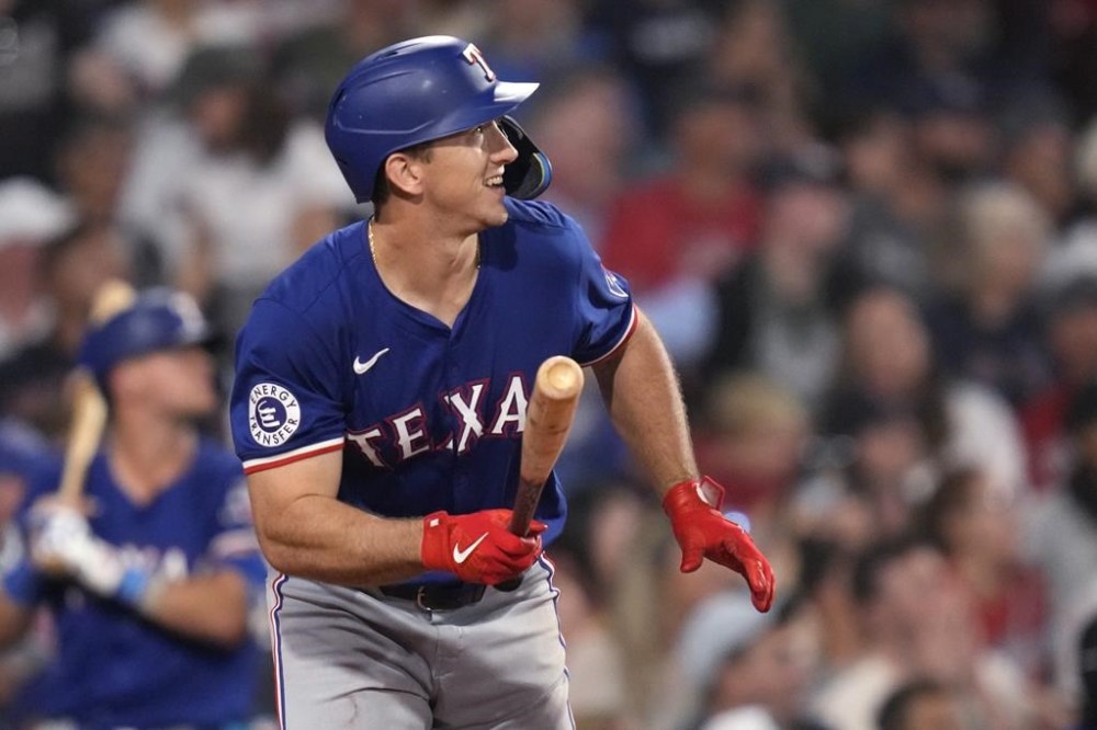 Texas Rangers' Wyatt Langford watches the flight of his three-run home run in the ninth inning of a baseball game against the Boston Red Sox at Fenway Park, Wednesday, Aug. 14, 2024, in Boston. (AP Photo/Charles Krupa)
