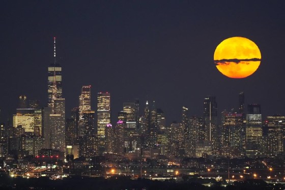 The moon rises through clouds over lower Manhattan in 2023, during a supermoon period. (Seth Wenig / The Associated Press files)