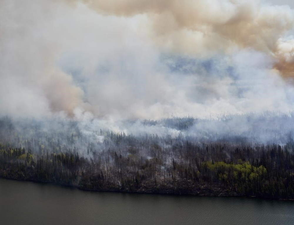 A wildfire burns in northern Manitoba as seen from a helicopter surveying the situation, on Tuesday, May 14, 2024. Many parts of northern Manitoba are under an air quality warning due to wildfire smoke, which is also causing reduced visibility. THE CANADIAN PRESS/David Lipnowski