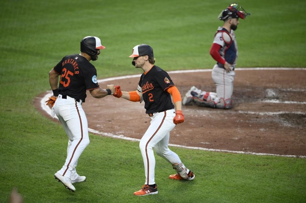 Baltimore Orioles' Gunnar Henderson (2) celebrates his two-run home run with Anthony Santander (25) during the fourth inning of a baseball game as Boston Red Sox catcher Connor Wong looks on at back right, Thursday, Aug. 15, 2024, in Baltimore. (AP Photo/Nick Wass)