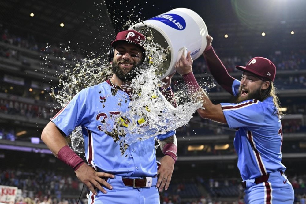 Philadelphia Phillies' Weston Wilson, center, is doused by teammates Brandon Marsh, right, and Bryson Stott after a victory over the Washington Nationals in a baseball game, Thursday, Aug. 15, 2024, in Philadelphia. (AP Photo/Derik Hamilton)