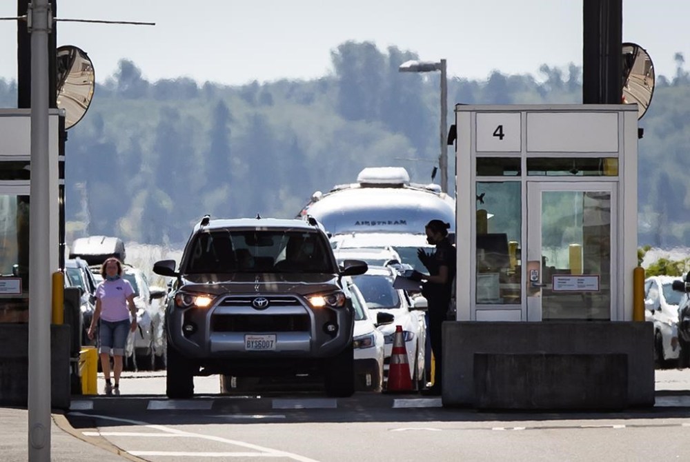 A Canada Border Services Agency officer speaks to a motorist entering Canada at the Douglas-Peace Arch border crossing, in Surrey, B.C., on Monday, August 9, 2021. THE CANADIAN PRESS/Darryl Dyck