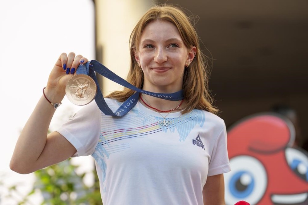 Romanian gymnast Ana Barbosu poses with the bronze medal for her women's artistic gymnastics individual floor performance at the Paris 2024 Olympics, after receiving it during a ceremony at the Romanian Olympic and Sports Committee, in Bucharest, Romania, Friday, Aug. 16, 2024. American gymnast Jordan Chiles called an arbitration panel's decision that dropped her out of the bronze medal position in the floor exercise at the Paris Olympics