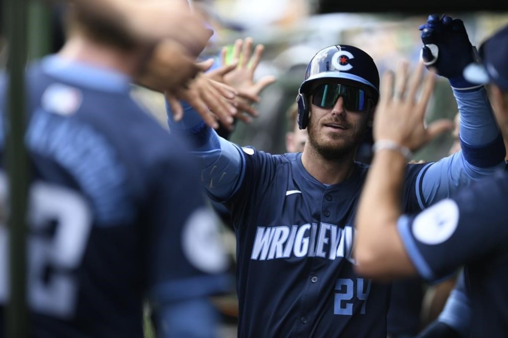 Chicago Cubs' Cody Bellinger (24) celebrates with teammates in the dugout after hitting a two-run home run during the first inning of a baseball game against the Toronto Blue Jays in Chicago, Friday, Aug. 16, 2024. (AP Photo/Paul Beaty)