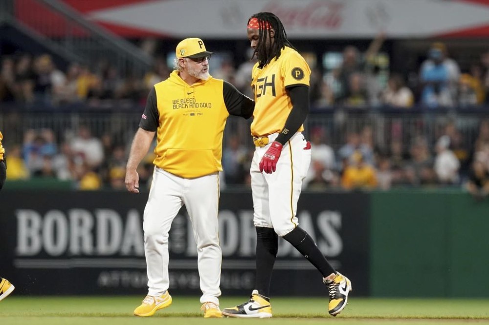 Pittsburgh Pirates' Oneil Cruz, right, leaves the field with manager Derek Shelton, left, after an injury during the seventh inning of a baseball game against the Seattle Mariners, Friday, Aug. 16, 2024, in Pittsburgh. (AP Photo/Matt Freed)
