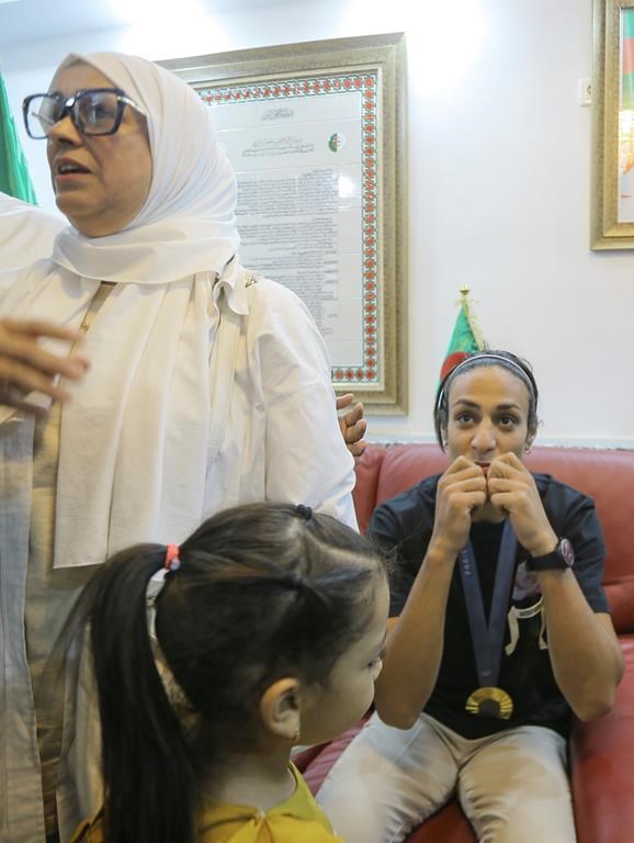 Olympic gold medalist in the the women's 66 kg boxing Algeria's Imane Khelif, right, reacts as she arrives home after returning from the 2024 Paris Olympic Games in Tiaret, Algeria, Friday, Aug. 16, 2024. (AP Photo/Anis Belghoul)