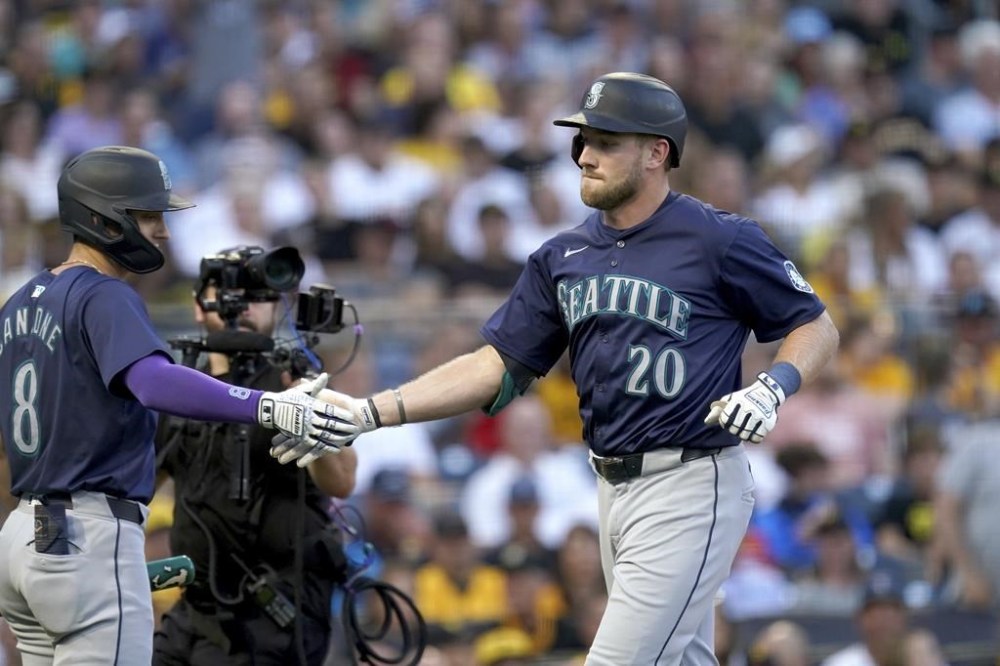 Seattle Mariners' Luke Raley, right, is greeted by Dominic Canzone, left, after he hit a two-run home run during the fourth inning of a baseball game against the Pittsburgh Pirates, Friday, Aug. 16, 2024, in Pittsburgh. (AP Photo/Matt Freed)