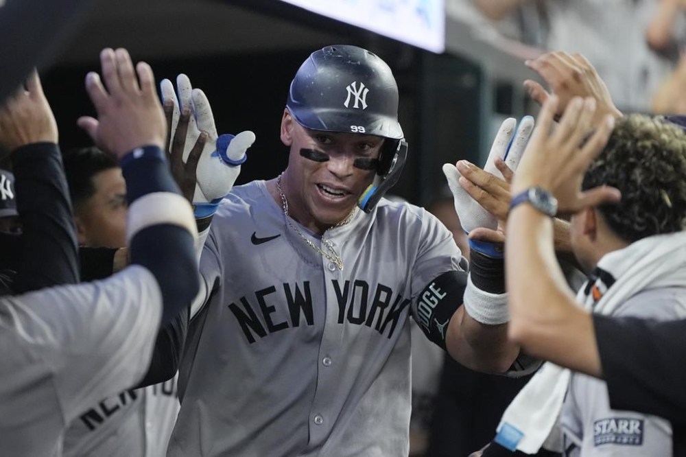 New York Yankees' Aaron Judge is greeted in the dugout after a solo home run during the eighth inning of a baseball game against the Detroit Tigers, Friday, Aug. 16, 2024, in Detroit. (AP Photo/Carlos Osorio)