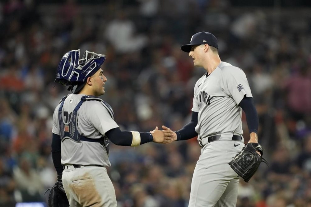 New York Yankees catcher Jose Trevino shakes hands with pitcher Clay Holmes after the ninth inning of a baseball game against the Detroit Tigers, Friday, Aug. 16, 2024, in Detroit. (AP Photo/Carlos Osorio)