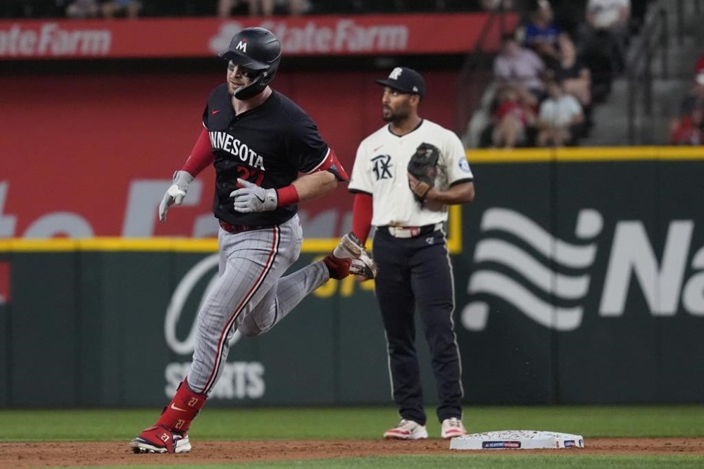 Minnesota Twins' Ryan Jeffers (27) runs the base past Texas Rangers second base Marcus Semien (2) after Jeffers hit a home run during the third inning of a baseball game in Arlington, Texas, Friday, Aug. 16, 2024. (AP Photo/LM Otero)