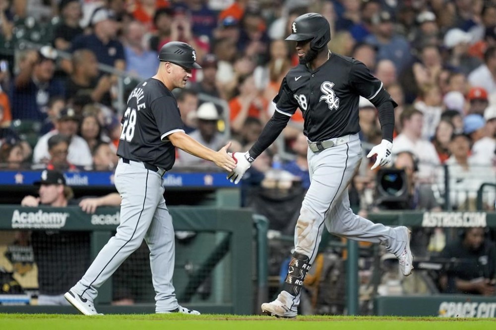 Chicago White Sox's Luis Robert Jr., right, celebrates after his two-run home run against the Houston Astros with third base coach Justin Jirschele, left, during the third inning of a baseball game Friday, Aug. 16, 2024, in Houston. (AP Photo/Eric Christian Smith)