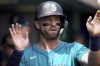 Seattle Mariners' Mitch Haniger celebrates in the dugout after scoring during the second inning of a baseball game against the Pittsburgh Pirates, Saturday, Aug. 17, 2024, in Pittsburgh. (AP Photo/Matt Freed)