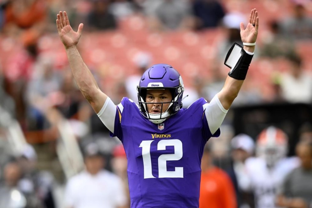 Minnesota Vikings quarterback Nick Mullens (12) celebrates his touchdown throw against the Cleveland Browns during the first half of an NFL preseason football game, Saturday, Aug. 17, 2024, in Cleveland. (AP Photo/David Richard)
