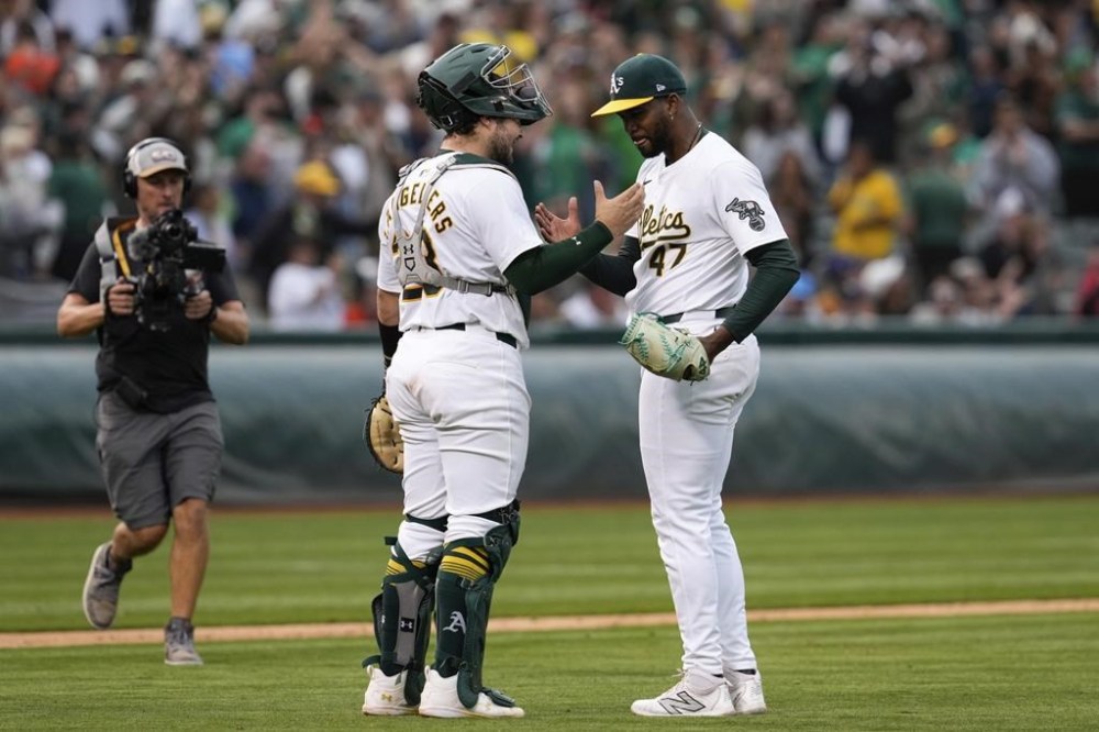 Oakland Athletics catcher Shea Langeliers, front left, and pitcher Michel Otañez, right, celebrate after their victory over the San Francisco Giants in a baseball game Saturday, Aug. 17, 2024, in Oakland, Calif. (AP Photo/Godofredo A. Vásquez)